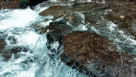 Small-waterfall-with-crystal-water-in-forest.-Slow-motion-of-blue-water-flow