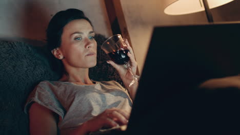 Mujer-Bebiendo-Vino-Tinto-Con-Una-Computadora-Portátil.-Chica-Navegando-Por-Internet-En-La-Computadora.