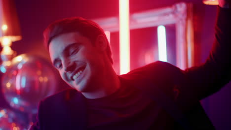 Positive-man-having-fun-on-neon-lights-background.-Guy-dancing-in-nightclub