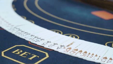 Close-up-of-hands-of-dealer-with-playing-cards-on-pocker-table