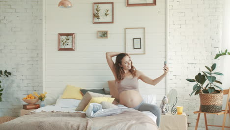 Smiling-expectant-mother-making-selfie-photo.-Pregnant-woman-relaxing-home.