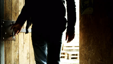 Man-entering-door.-Biker-come-in-garage.-Close-up-of-entering-door-in-dark