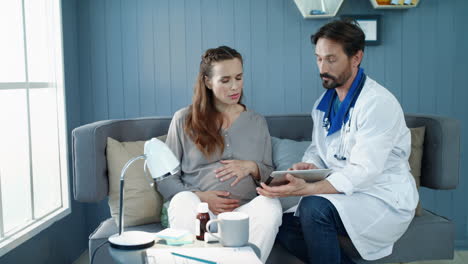 Male-gynecologist-explaining-tests-results-to-pregnant-woman-in-office.
