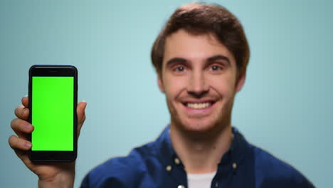 Man-showing-mobile-phone-with-green-screen.Student-showing-phone-with-chroma-key