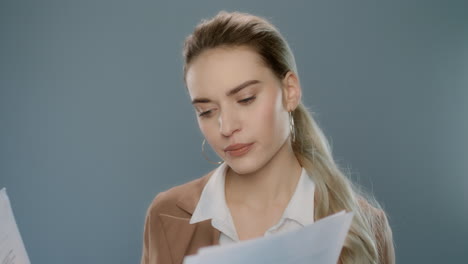 Thoughtful-business-woman-looking-documents.-Serious-person-holding-papers