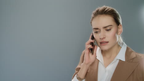 Mujer-De-Negocios-Enojada-Llamando-Al-Teléfono-Móvil-En-El-Estudio.-Empresaria-Enojada