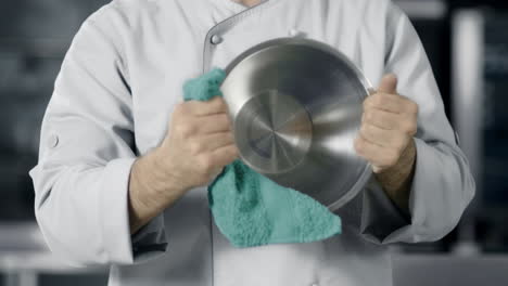 Chef-man-preparing-to-cook-at-kitchen-restaurant.-Closeup-hands-wipe-bowl.
