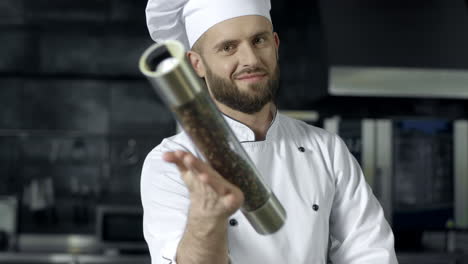 Chef-male-portrait-at-kitchen-restaurant.-Male-chef-playing-with-pepperbox