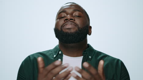 Portrait-of-serious-african-american-man-showing-cross-hand-in-studio.