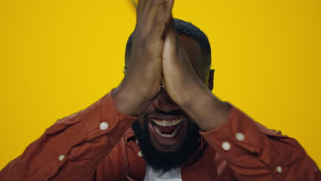 Portrait-of-happy-african-man-celebrating-victory-on-yellow-background.