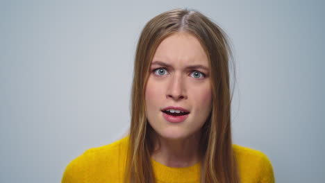 Portrait-of-angry-woman-screaming-with-aggressive-emotion-at-camera-in-studio.