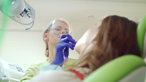 Dentista-Sonriente-Trabajando-Con-El-Paciente-En-El-Consultorio-Dental.-Profesional-De-Estomatología