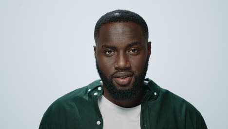 Portrait-of-smiling-african-handsome-raising-head-in-grey-background.