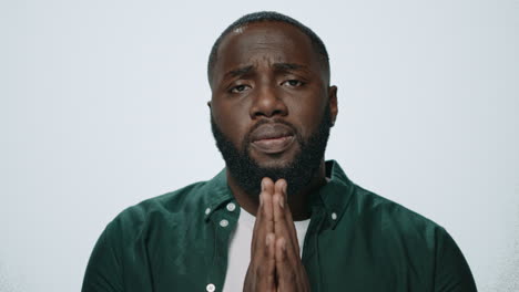 Portrait-of-african-american-man-praying-on-grey-background.-Meditation-concept