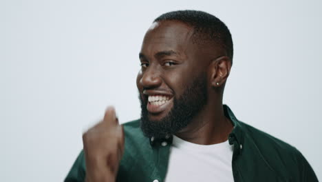 Portrait-of-cheerful-african-american-guy-dancing-on-grey-background.