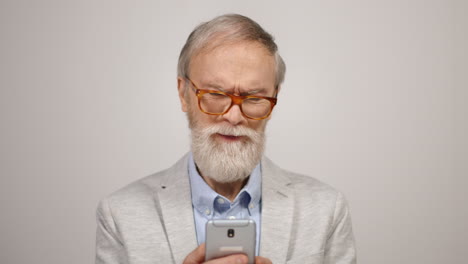 Anciano-Molesto-Usando-El-Teléfono-En-El-Estudio.-Chico-Concentrado-Poniéndose-Gafas-En-El-Interior.
