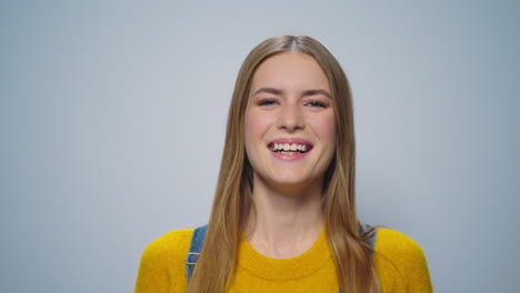 Porträt-Einer-Glücklichen-Frau,-Die-Im-Studio-Auf-Grauem-Hintergrund-In-Die-Kamera-Lächelt.