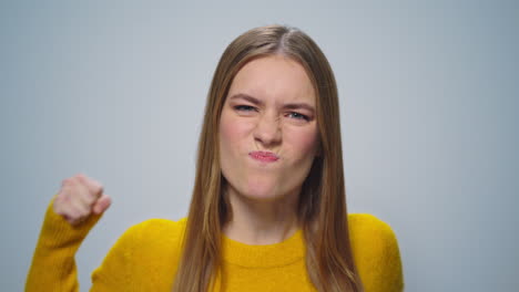 Portrait-of-stressed-woman-posing-with-hands-gestures-on-grey-background.