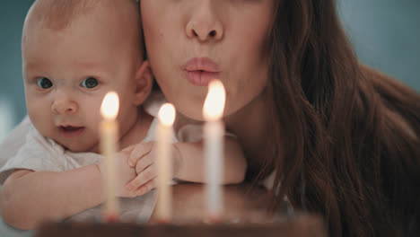 Mujer-Con-Bebé-Soplando-Velas-En-El-Pastel-De-Cumpleaños.-Fiesta-De-Cumpleaños-Familiar