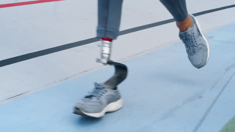 Woman-with-prosthetic-leg-running-on-track.-Sportsperson-exercising-at-stadium