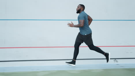 Afroamerikanischer-Mann-Joggt-Im-Stadion.-Läufer-Macht-Cardio-Training-Im-Freien