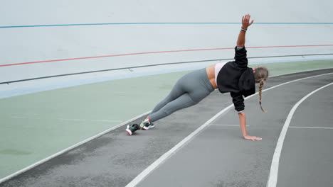Disabled-athlete-standing-in-plank-on-hand-at-track.-Girl-practicing-yoga