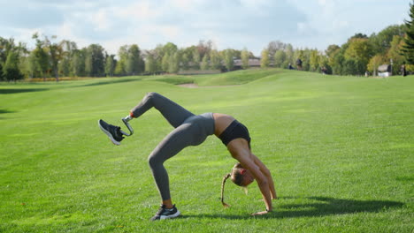 Woman-with-prosthetic-leg-doing-yoga-in-field.-Girl-standing-in-bridge-pose