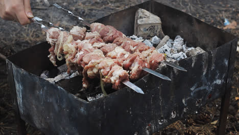 Hände-Legen-Fleischspieße-Auf-Den-Holzkohlegrill.-Fleischgrillen-Auf-Dem-Grill