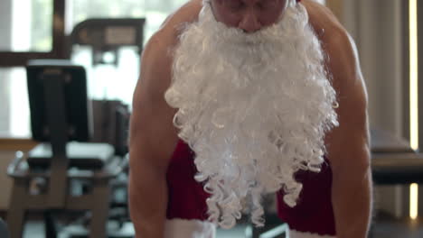 Focused-santa-man-making-repetitions-in-sport-club.-Fitness-man-in-santa-costume