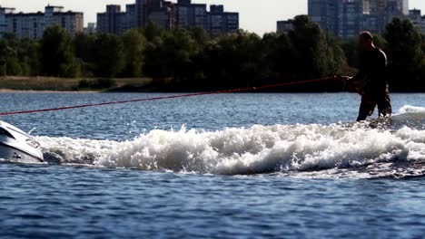 Wake-surfer-riding-board-on-river-in-sunny-day.-Extreme-lifestyle-concept