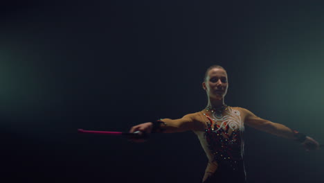 Pretty-woman-spinning-around-with-mace.-Rhythmic-gymnast-rehearsing-indoors.