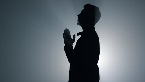 Silhouette-Eines-Religiösen-Mannes,-Der-Drinnen-Gebete-Flüstert.-Gläubige-Beten-Im-Dunkeln.