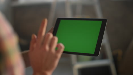 Woman-hand-touching-green-screen.-Unknown-girl-working-on-tablet-indoors.