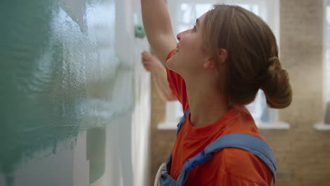 Happy-family-painting-wall-indoors.-Couple-having-fun-while-home-repair.