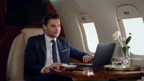 Focused-businessman-looking-computer-on-corporate-trip.-Wealthy-man-work-laptop