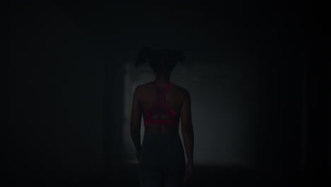 Girl-walking-in-dark-corridor.-Athlete-taking-break-after-cardio-workout