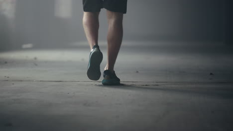 Male-athlete-feet-walking-in-loft-building.-Man-legs-going-for-training