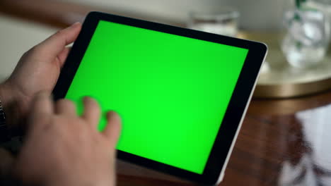 Erwachsene-Hand-Wischt-Nahaufnahme-Des-Grünen-Tablet-Bildschirms.-Mann-Hält-Chroma-Key-Computer