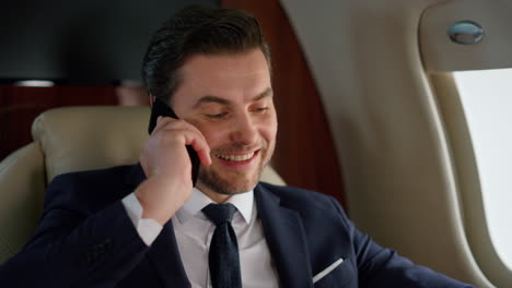 Portrait-successful-businessman-calling-partner-on-corporate-airplane-trip.