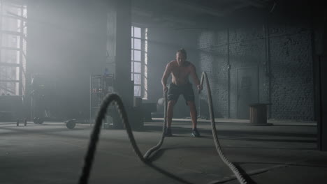 Man-practicing-exercise-with-battle-ropes.-Sportsman-doing-functional-training