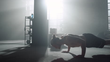 Man-standing-in-plank.-Guy-doing-push-ups-during-fitness-session-in-sport-club