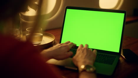 Hands-typing-green-laptop-closeup.-Airplane-passenger-resting-browsing-internet