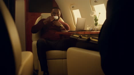 Successful-businessman-browse-online-at-airplane-window.-Ceo-on-business-travel