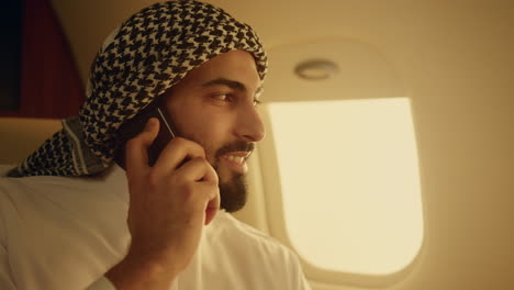 Hombre-De-Negocios-árabe-Hablando-Por-Teléfono-Celular-En-Primer-Plano-Del-Avión.-Hombre-Confiado-Viajando