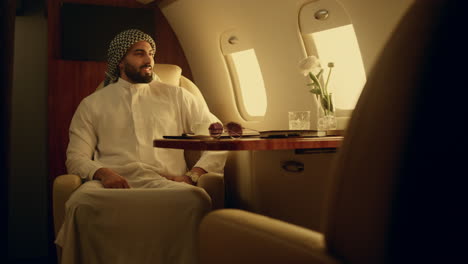 Muslim-businessman-enjoying-airplane-trip.-Successful-man-checking-hand-watch