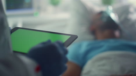Doctor-holding-tablet-chroma-key-screen-checking-patient-medical-history-closeup