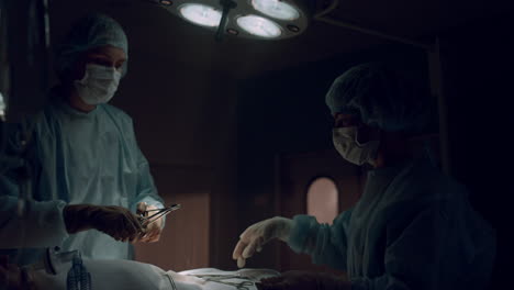 Trabajadores-Médicos-Profesionales-Que-Realizan-Operaciones-En-Un-Quirófano-Oscuro.