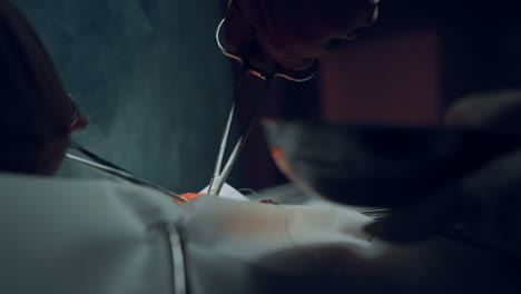 Closeup-surgeon-hands-suturing-wound-with-forceps-in-hospital-operating-theatre.