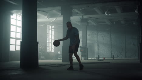 Basketball-player-training-in-sport-club.-Sporty-man-dribbling-ball-between-legs