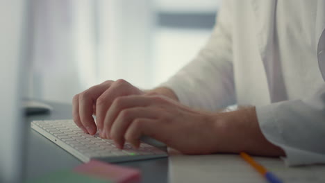 Closeup-doctor-hands-typing-on-computer-keyboard.-Physician-working-remotely.